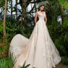 Braut in einem eleganten Prinzessin-Brautkleid mit floralen Spitzenapplikationen, fotografiert in einem tropischen Gewächshaus