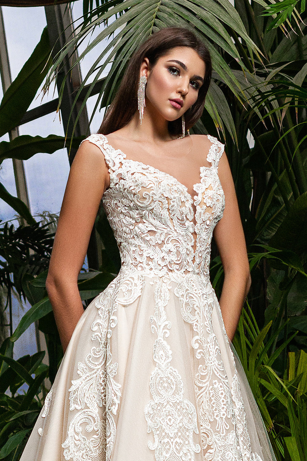 Detailaufnahme des Brautkleids mit feiner floraler Spitze, zarten Trägern und halbtransparentem Mieder.