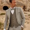 Grauer Bräutigamanzug mit Weste und Fliege – stilvoller Hochzeitslook für moderne Bräutigame in natürlicher Kulisse.