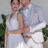 Beigefarbener Bräutigamanzug mit gemusterter Fliege und Weste – stilvoller Hochzeitslook im eleganten Paarshooting mit Braut.