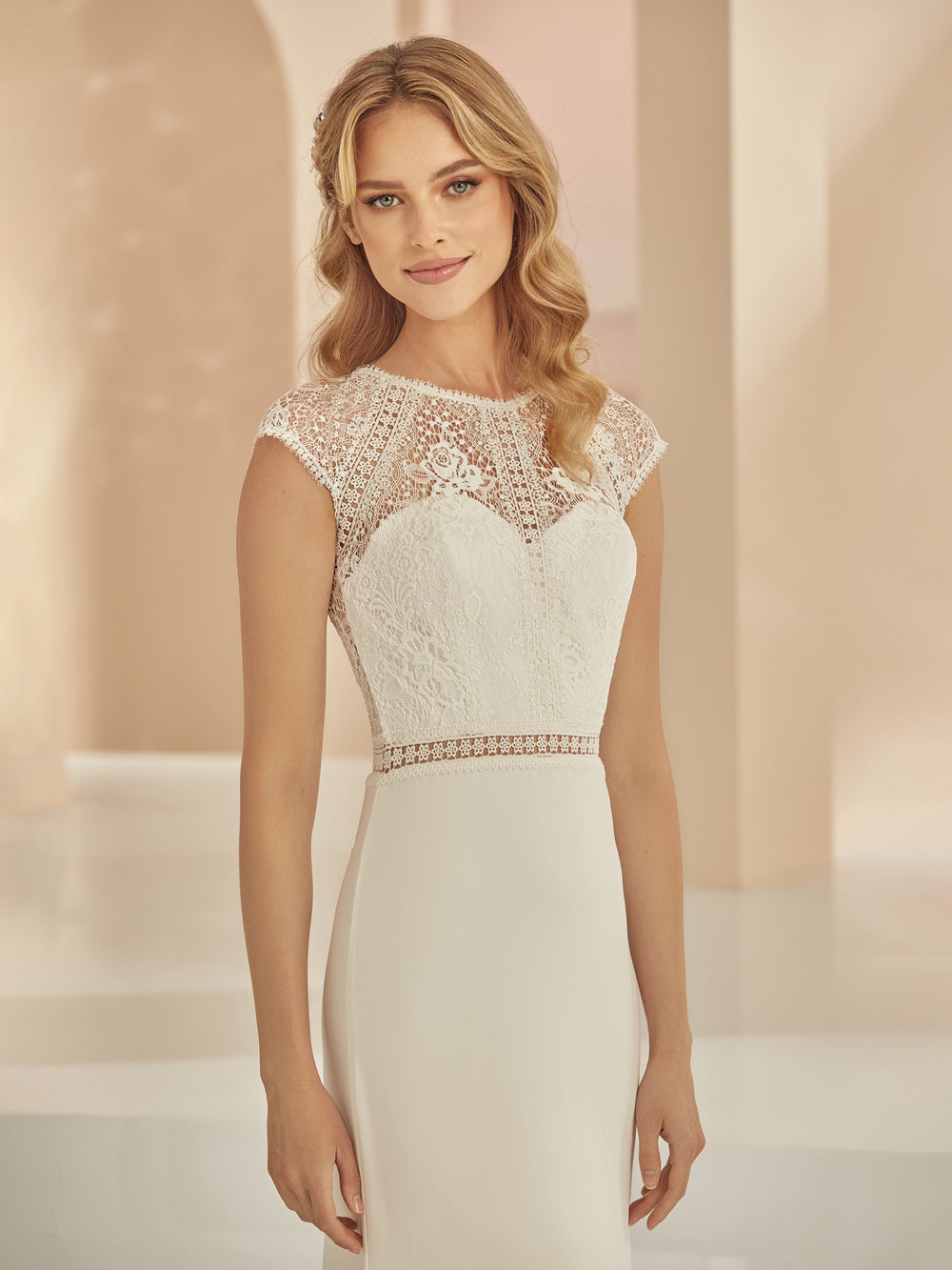 Nahaufnahme des Fit & Flare Brautkleides mit feiner Spitze und Cap-Ärmeln