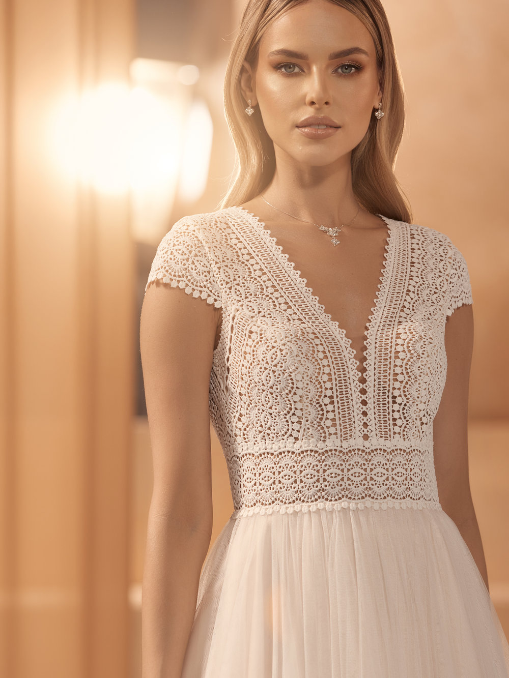 Detailaufnahme des Spitzenoberteils mit tiefem V-Ausschnitt und zarter Häkelspitze bei Boho Brautkleid