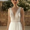 Detaillierte Nahaufnahme eines Boho & Vintage Brautkleids mit tiefem V-Ausschnitt und floraler Häkelspitze
