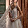 Detailaufnahme der funkelnden Corsage mit transparenten Trägern und tiefem V-Ausschnitt, verziert mit Glitzer und feiner Spitze.