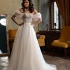 Romantische Frontansicht eines Prinzessin-Brautkleides mit schulterfreien Puffärmeln, glitzerndem Oberteil und weitem Tüllrock.