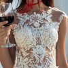 Detailaufnahme des Brautkleids mit feiner floraler Spitze, zarten Trägern und halbtransparentem Mieder.