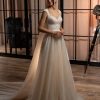 Prinzessinnen-Brautkleid mit zartem Glitzertüllrock, besticktem Oberteil und eleganter Knopfleiste – aufgenommen in einem stilvollen Loft mit Holzboden und Studio-Ambiente.