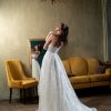 Rückenansicht eines Brautkleides mit transparentem Rückenteil, verziert mit zarten Details und einem verdeckten Reißverschluss.