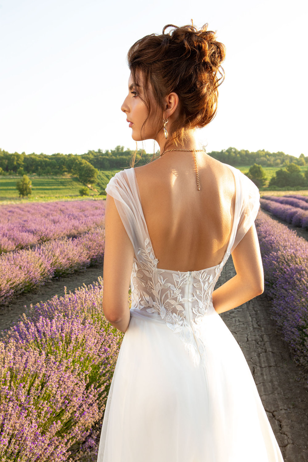 Nahaufnahme eines eleganten A-Linien Brautkleides mit feinen Trägern und floraler Stickerei am Oberteil.