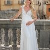 Umstandsbrautkleid mit Spitzenoberteil und fließendem Rock, getragen von einer schwangeren Braut vor historischer Altstadtkulisse