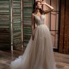 Prinzessin Brautkleid mit tiefem V-Ausschnitt und floral besticktem Spitzenoberteil, Tüllrock in fließender A-Linie, fotografiert vor rustikalem Holzdekor.