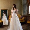 Romantisches Prinzessin Brautkleid mit zartem Tüllrock und aufwendig besticktem Oberteil, fotografiert in einem Vintage-Raum mit Spiegel und Kronleuchter.