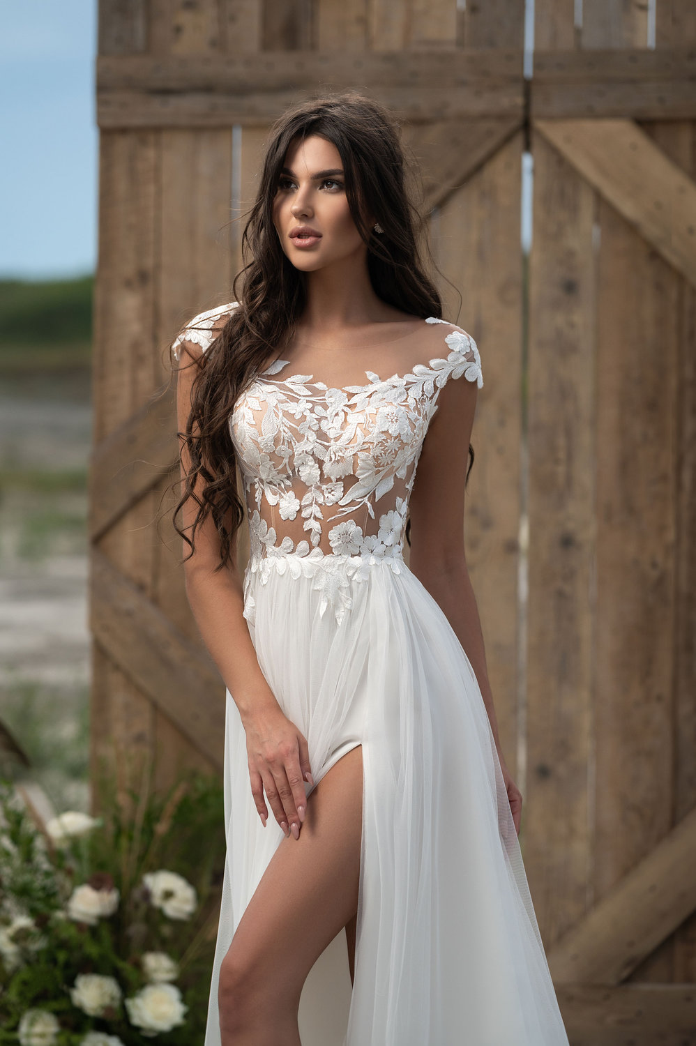 Nahaufnahme von A-Linie Brautkleid mit transparentem Spitzenoberteil und Schlitz im Tüllrock