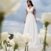 A-Linie Brautkleid mit Spitzenrock, kurzen Ärmeln und langer Knopfleiste, vorne fotografiert unter blauem Himmel
