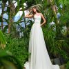 A-Linie Brautkleid mit fließendem Rock und Herzausschnitt, fotografiert in tropischer Gartenkulisse.