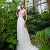 A-Linie Brautkleid mit floraler Spitze und fließendem Tüllrock, aufgenommen in einem tropischen Gewächshaus.