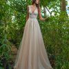 A-Linie Brautkleid mit tiefem V-Ausschnitt, Spitzenoberteil und fließendem Tüllrock, aufgenommen im Gewächshaus.