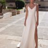 Schlichtes Brautkleid mit Spaghettiträgern, V-Ausschnitt und Beinschlitz, fotografiert im Sonnenlicht auf modernem Platz