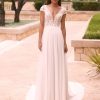 Romantisches Brautkleid mit floraler Spitze, tiefem V-Ausschnitt, kurzen Ärmeln und fließendem Rock, aufgenommen im Gartenbereich