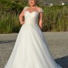 Prinzessinnen Brautkleid mit Herzausschnitt, transparenten Trägern und ausgestelltem Rock, getragen von einer Curvy Braut in der Natur
