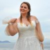 Detailaufnahme eines modernen Curvy Brautkleids mit Herz-Ausschnitt, zarter Spitze und langen Tüllärmeln mit Perlenmanschette.