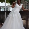 Plus Size Brautkleid mit herzförmigem Ausschnitt, floraler Spitze und Tüllrock, fotografiert an der Holzgitter